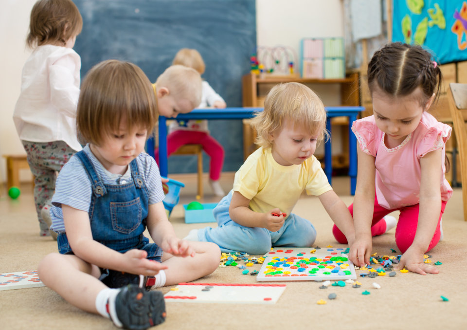 kids or children playing mosaic game in kindergarten room