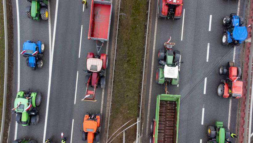 Poznań, 20.02.2024. Na zdjęciu z drona rolnicy blokują węzeł autostrady A2 Poznań-Komorniki, 20 bm. Rolnicy z całej Polski kontynuują protesty. Ich powodem jest m.in. niedawna decyzja Komisji Europejskiej o przedłużeniu bezcłowego handlu z Ukrainą do 2025 roku, a także sprzeciw wobec prowadzonej przez Unię Europejską polityki Zielonego Ładu. Fot. PAP/Jakub Kaczmarczyk