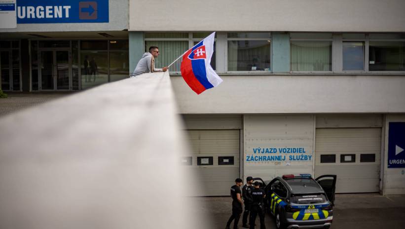 A man waves Slovak national flag as police car is parked outside the F. D. Roosevelt University Hospital, where Slovak Prime Minister Robert Fico is being treated after being shot on 15 May, in Banska Bystrica, Slovakia, 16 May 2024. The Slovak government office on 15 May confirmed there had been an assassination attempt on Prime Minister Robert Fico following a meeting in the town of Handlova. According to Slovak Defence Minister Kalinak on 16 May, Fico was in stable but serious condition after surgery. Fot. PAP/EPA/MARTIN DIVISEK