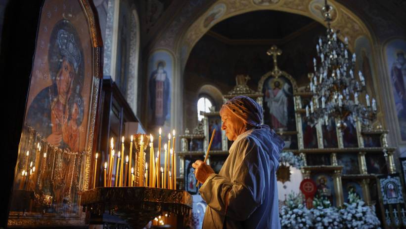 Ukrainian woman lights a candle after the blessing of baskets containing painted eggs and kulichi, a traditional Easter cake, in the St. Feodosia Monastery in Kyiv, Ukraine, 04 May 2024. Ukrainian Orthodox Christians will celebrate Easter on 05 May 2024, amid the ongoing Russian invasion. Fot. PAP/EPA/SERGEY DOLZHENKO