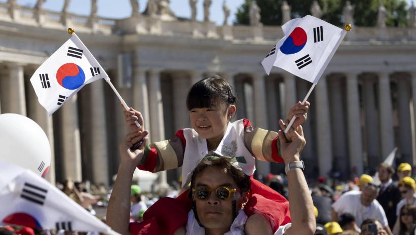 A girl on a man's shoulders waves small South Korean flages as faithful wait in Saint Peter's Square for the arrival of the Pope ahead of a mass on World Children's Day at Saint Peter's Basilica, in Vatican City, 26 May 2024. The World Children's Day celebration move to St. Peter's Square on 26 May, to be presided over by Pope Francis, and will culminate with the Angelus and the Pope's greeting to children from around the world. Fot. PAP/EPA/MASSIMO PERCOSSI