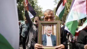 Iranians carry the portrait of late Hamas political leader Ismail Haniyeh and wave Palestinian flags during a protest at Tehran University in Tehran, Iran, 31 July 2024. According to an Iranian Revolutionary Guard Corps (IRGC) statement on 31 July, Hamas political leader Ismail Haniyeh and one of his bodyguards were targeted and killed in Tehran on 31 July 2024. Fot. PAP/EPA/ABEDIN TAHERKENAREH