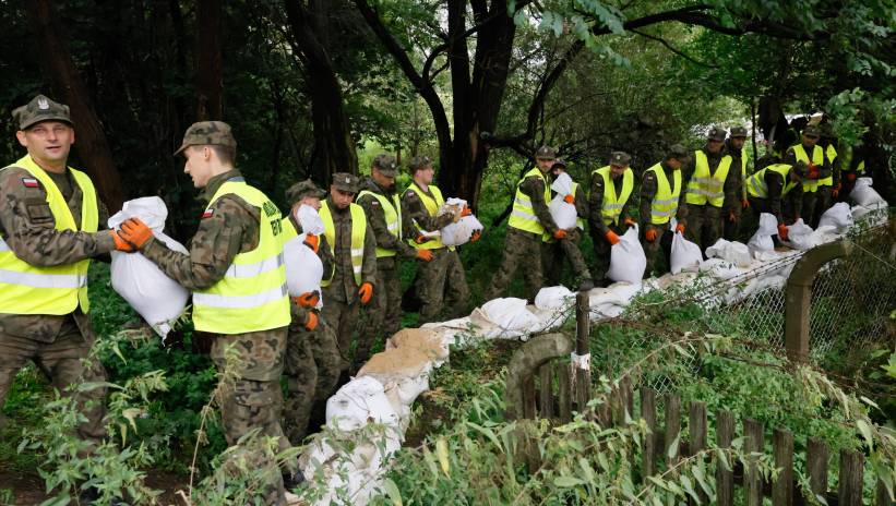 Fot. PAP/Tomasz Wojtasik
Ostrów Wielkopolski, 14.09.2024. Żołnierze 12. Wielkopolskiej Brygady Obrony Terytorialnej układają worki z piaskiem na terenie zagrożonym powodzią w Ostrowie Wielkopolskim, 14 bm. Niż genueński, który dotarł nad Polskę w czwartek 12 września, odpowiada za aktualne załamanie pogody i ulewne deszcze. (aldg) PAP/Tomasz Wojtasik