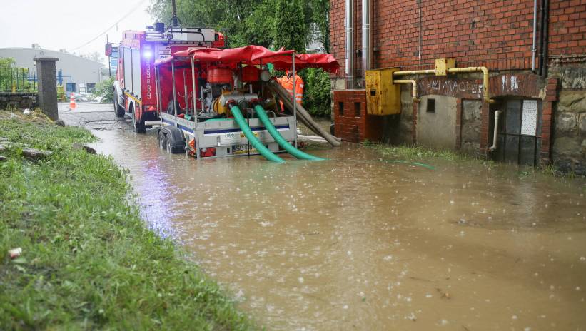 Bielsko-Biała, 04.06.2024. Strażacy podczas odpompowywania wody z zalanej posesji przy ul. Konwaliowej w Bielska-Białej, 4 bm. Po intensywnych opadach deszczu w Bielsku-Białej i powiecie bielskim woda zablokowała wiele dróg i utrudniła ruch na kolei, zalanych zostało wiele piwnic, samochodów i posesji. Fot. PAP/Jarek Praszkiewicz