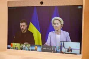 Foto: Przewodnicząca Komisji Europejskiej Ursula van der Leyen (z prawej) i prezydent Ukrainy Wołodymyr Zełenski pojawiają się na ekranie podczas wideokonferencji z prezydentem Francji w ramach tzw. „Koalicji chętnych” w Forcie Bregancon w Bormes-les-Mimosas na południu Francji, 17 sierpnia 2025 r. (Zdjęcie: Philippe Magoni / POOL / AFP) / Źródło: kyivpost.com