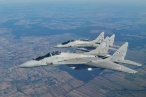 Dwa myśliwce MiG-29 biorą udział w ćwiczeniach osłony powietrznej NATO w pobliżu bazy lotniczej w Łasku, w centralnej Polsce, 12 października 2022 r. (Zdjęcie: RADOSŁAW JOŹWIAK / AFP)