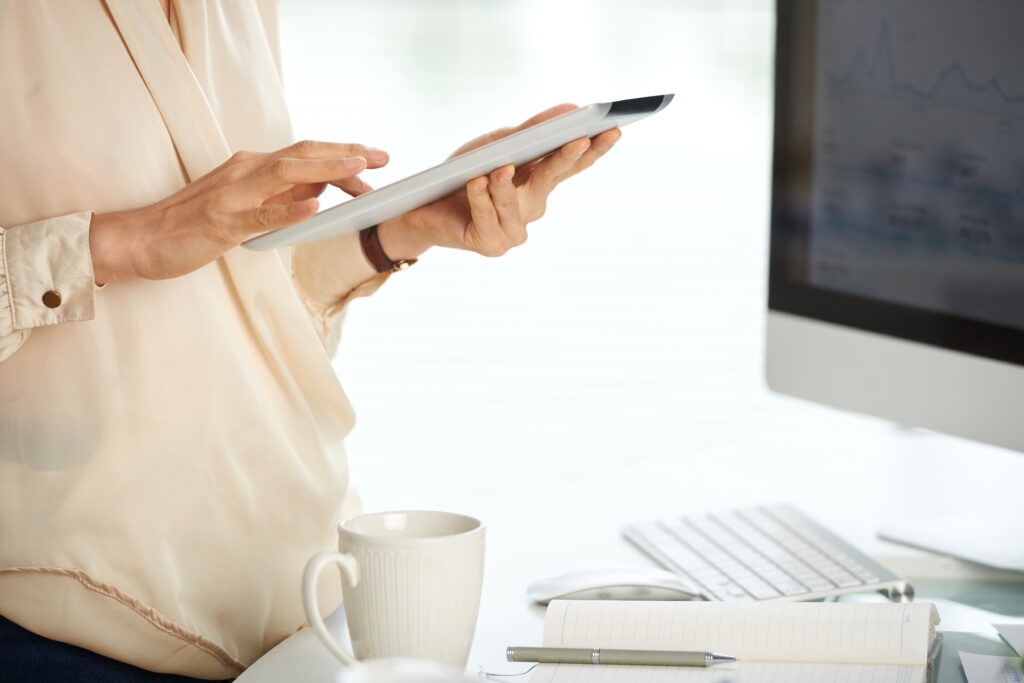 Hands of unrecognizable young businesswoman using tablet computer