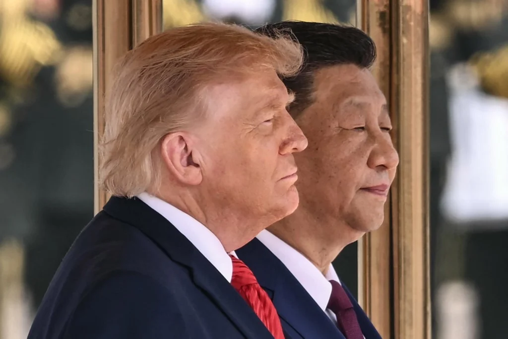 Foto: Prezydent USA Donald Trump (z lewej) i prezydent Chin Xi Jinping wstają, by odśpiewać hymny narodowe swoich krajów podczas ceremonii powitalnej w Wielkiej Hali Ludowej w Pekinie, 14 maja 2026 r. (Zdjęcie: Brendan SMIALOWSKI / AFP) / Źródło: kyivpost.com