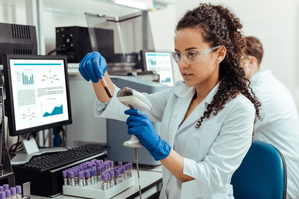 Safety rules. Smart young woman wearing special protective glasses while working in the lab